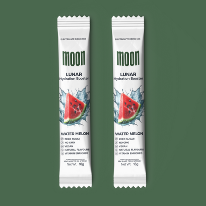 Two packets of Moon Lunar Watermelon Hydration Stick Pack of 2 by MOONFREEZE FOODS PRIVATE LIMITED, displayed vertically on a green background. The bright packaging highlights key features such as zero sugar and vegan content, along with being electrolyte-rich for optimal hydration.