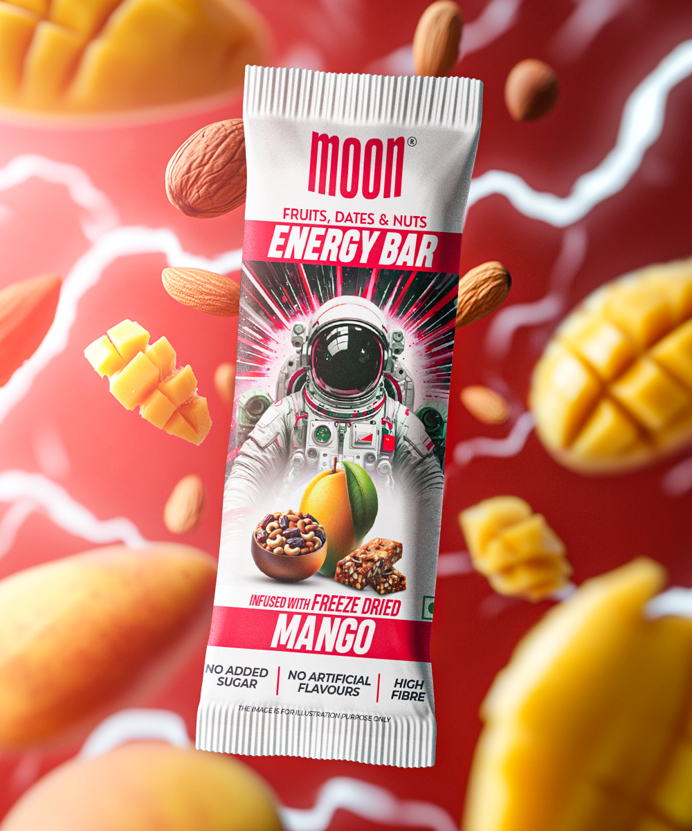 A pack of MOON Energy Bars - Mango by MOONFREEZE FOODS PRIVATE LIMITED on a vibrant background with mangoes and almonds. The wrapper features an astronaut graphic and highlights the freeze-dried fruits, high fiber, and no added sugar qualities, making it an ideal meal replacement for those on the go.