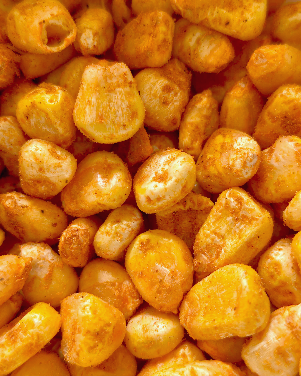 A close up image of a pile of Freeze Dried Crispy Corn Peri Peri chips from MOONFREEZE FOODS PRIVATE LIMITED.