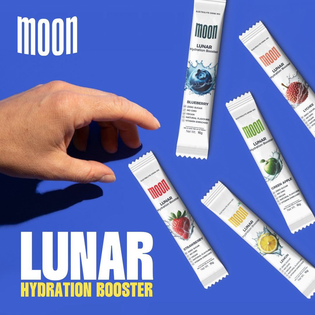 A hand reaching for packs of Moon Lunar Strawberry Hydration Stick Pack of 2 and other Moon Lunar Hydration Boosters in various flavors, displayed against a blue background, showcasing their vitamin-enriched and electrolyte-rich benefits by MOONFREEZE FOODS PRIVATE LIMITED.