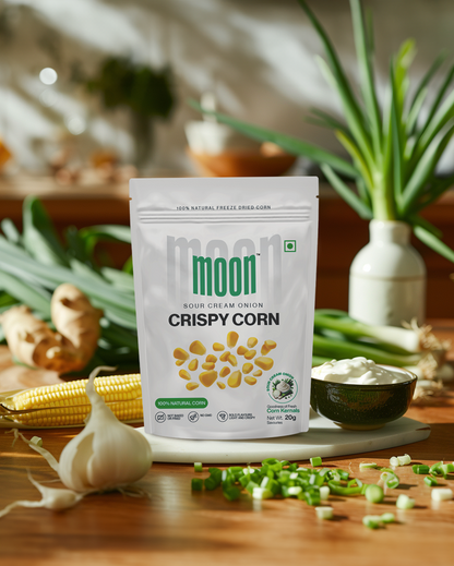 A bag of Freeze Dried Crispy Corn Sour Cream & Onion by MOONFREEZE FOODS PRIVATE LIMITED on a wooden table, perfectly seasoned.