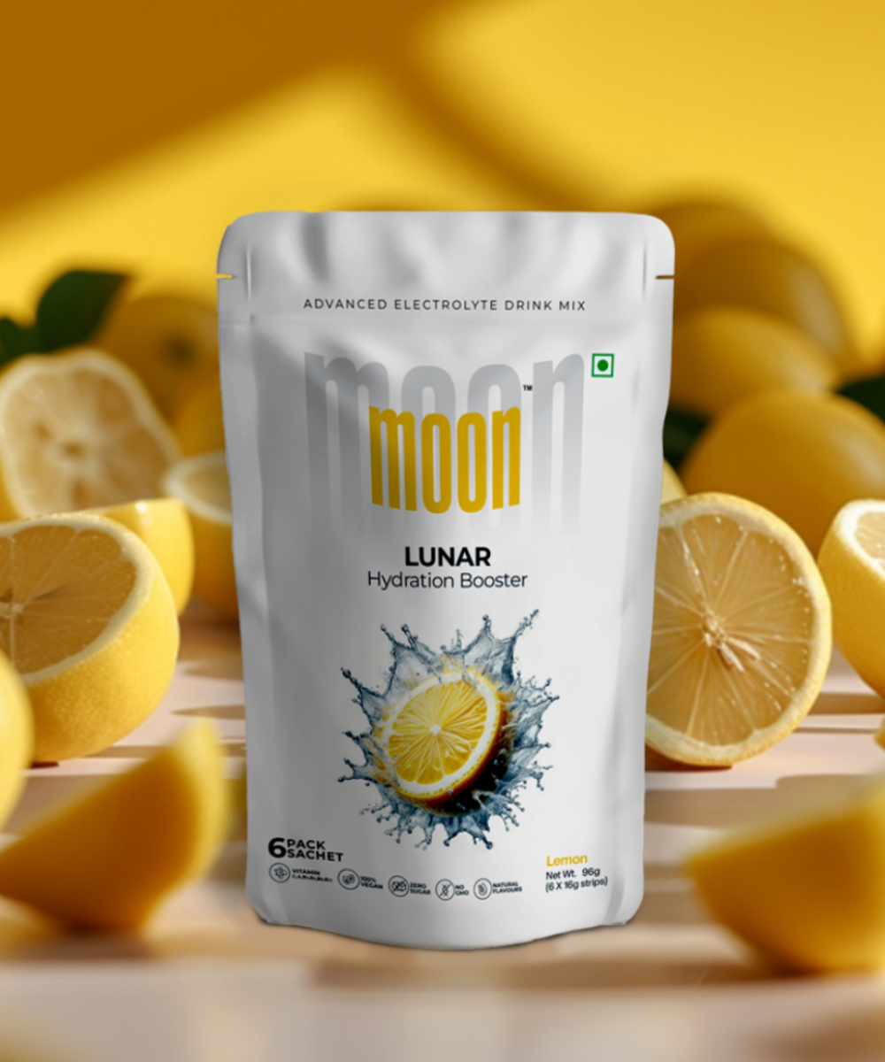 Product packaging for "Moon Freeze Cosmic Bulk Packs - Mega Hydrate Edition" electrolyte drink mix with lemon flavor, displayed in front of a background with sliced lemons and mango cubes.