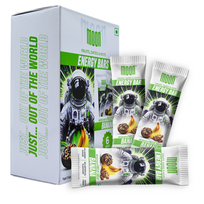 The packaging of MOONFREEZE FOODS PRIVATE LIMITED's MOON Energy Bar - Mango (6 Pack) features an astronaut illustration and is labeled "Fruits, Dates & Nuts, Banana Crunch." The box and individual bar wrappers are prominently displayed with the text "Out of this World," emphasizing the inclusion of freeze-dried mangoes as a delicious meal replacement.