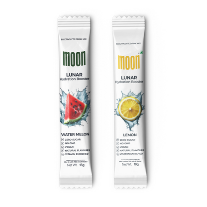 Two electrolyte drink mix sticks side by side. The one on the left has a watermelon image and the one on the right has a lemon image. Both labeled "Moon," with "Lunar Hydration Booster" in green text, promising enhanced hydration and essential vitamins for optimal performance. These are part of the Moon Lunar Lemon and Strawberry Hydration Stick Combo from MOONFREEZE FOODS PRIVATE LIMITED.