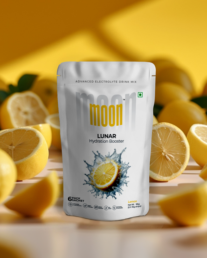 A package of Moon Lunar Watermelon + Lemon Hydration Booster electrolyte drink mix, surrounded by fresh lemon slices, against a yellow background.