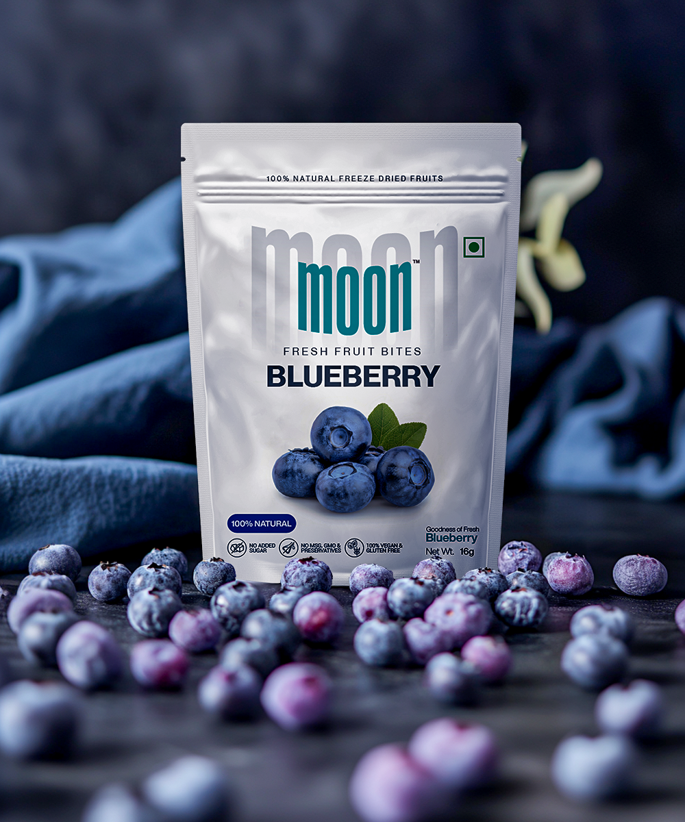 Fresh Fruit Bites in Blueberry flavor, surrounded by fresh blueberries, emphasizing the natural and vibrant essence of the product.