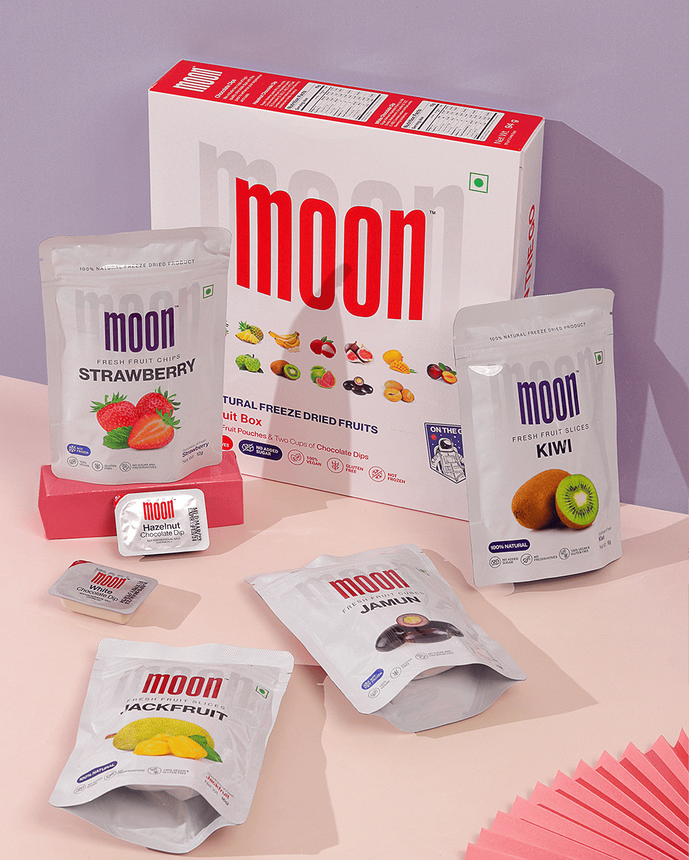 A box of Moon Freeze Dried Super Exotic Dip it fruit snacks from Themoonstoreindia on a pink background.
