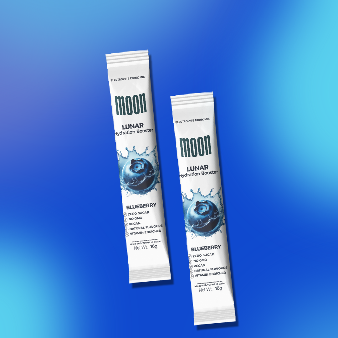 Two packets of Moon Lunar Blueberry Hydration Stick Pack of 2 from MOONFREEZE FOODS PRIVATE LIMITED are displayed against a blue gradient background. Each electrolyte-rich packet indicates it contains zero sugar, natural flavors, and is vitamin-infused with vitamin C.