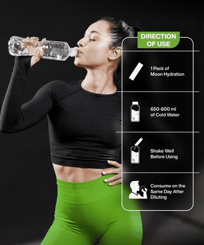 A woman in athletic wear drinks from a water bottle. Instructions for using the Lunar Hydration Booster - Green Apple from MOONFREEZE FOODS PRIVATE LIMITED are shown: add to 650-800 ml of cold water, shake well, and consume the same day for an electrolyte-rich experience.